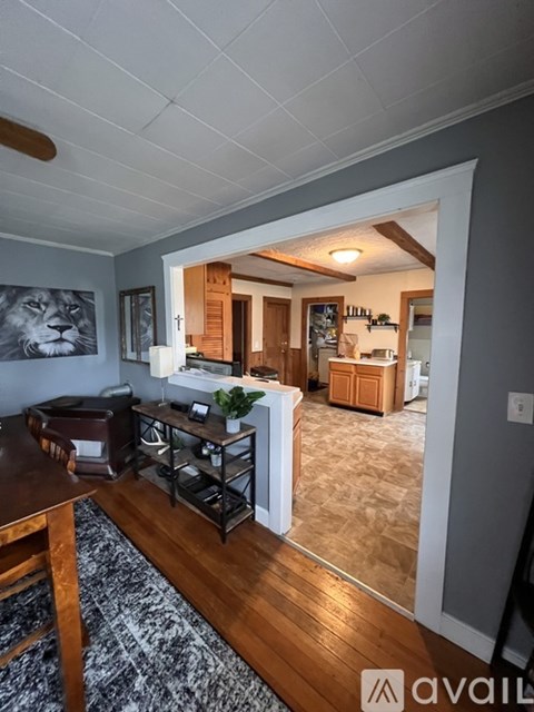A living room with a couch, a coffee table, and a painting of a lion on the wall.