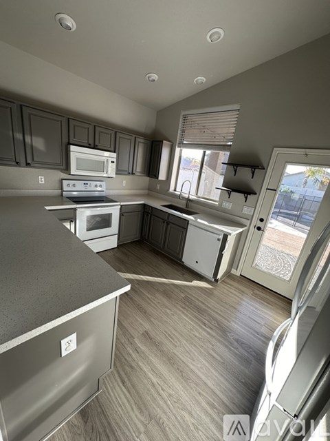 A kitchen with a white stove top oven and a microwave above it.