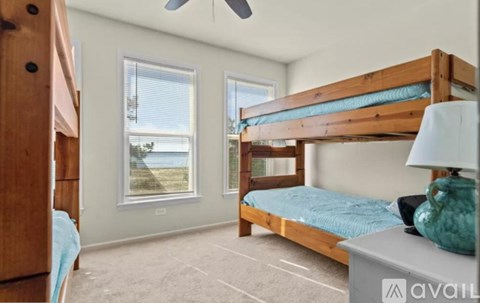 A bedroom with a bunk bed and a ceiling fan.