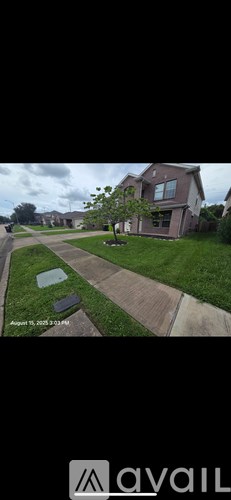 A house with a lawn and a tree in front of it.