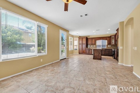 A spacious living room with a kitchen in the background.