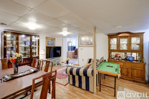 A living room with a pool table and a television.