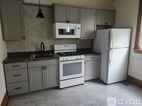 A kitchen with a white fridge, white oven, and white microwave.