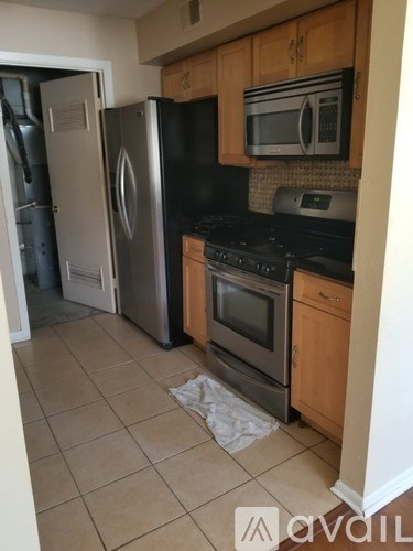 A kitchen with a black fridge, black stove, and a black microwave.