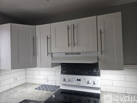 A kitchen with a white oven and black countertop.