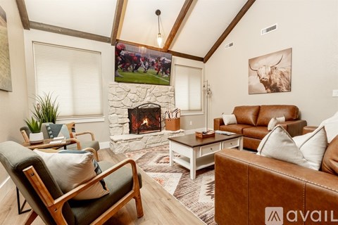 A living room with a stone fireplace and a large painting of a bull on the wall.