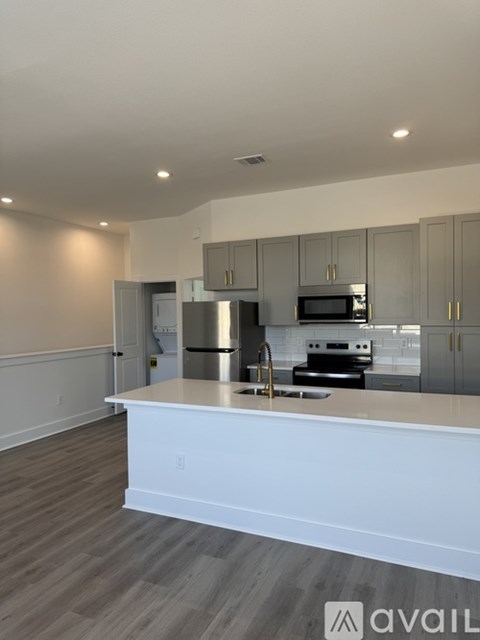 A kitchen with a white countertop and stainless steel appliances.