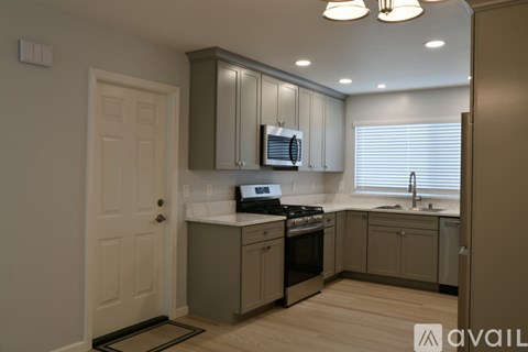 A kitchen with a white countertop and a stove top oven.