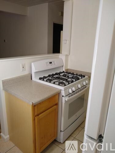 A white stove top oven with a white refrigerator in a kitchen.