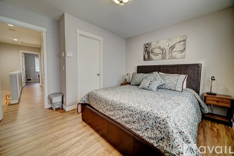 A bedroom with a large bed and a painting on the wall.