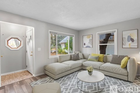 A living room with a grey couch and a white coffee table.