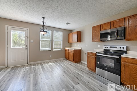 A kitchen with wooden cabinets and a stainless steel oven.