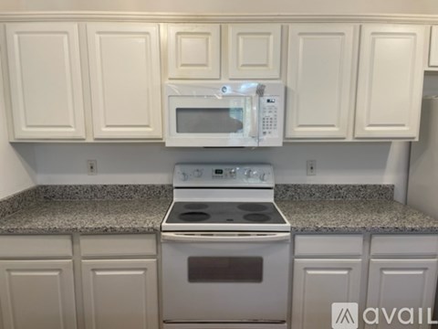 A kitchen with white cabinets and a granite countertop.