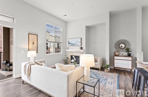 A modern living room with a white sofa and a fireplace.