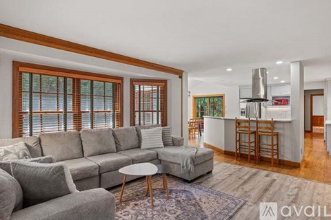 A living room with a grey sofa and a round table.