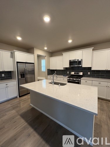 A kitchen with a white countertop and wooden cabinets.