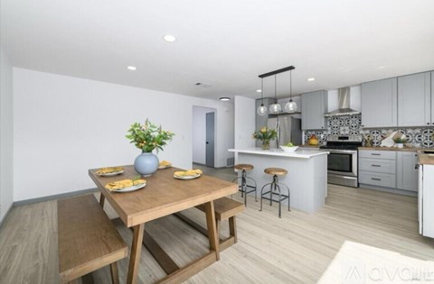 A modern kitchen with a dining table set for four.