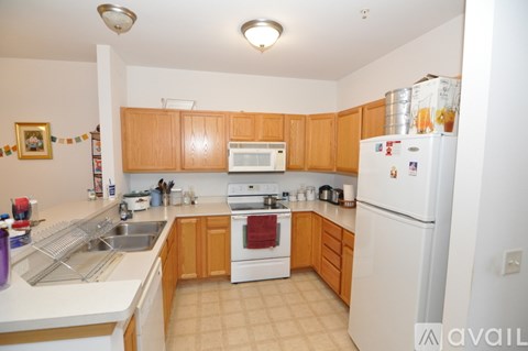 A kitchen with wooden cabinets and white appliances.