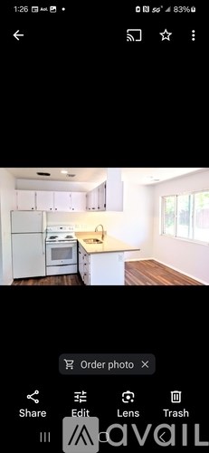 A kitchen with white cabinets and a white fridge.