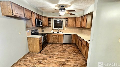 A kitchen with wooden cabinets and a black stove top oven.