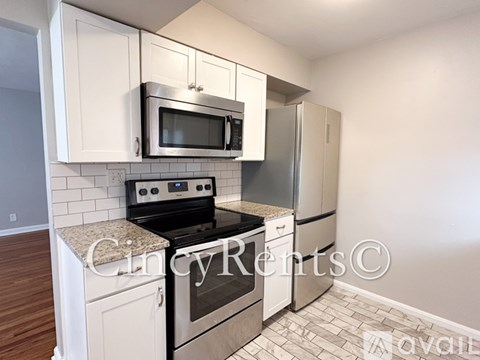A kitchen with white cabinets and a black stove top oven.