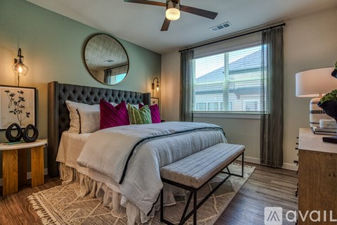 A bedroom with a large bed and a ceiling fan.