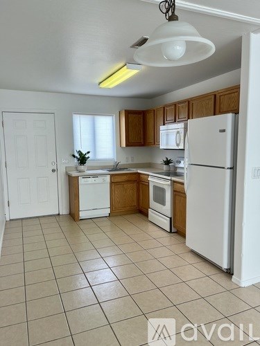 A kitchen with white appliances and wooden cabinets.
