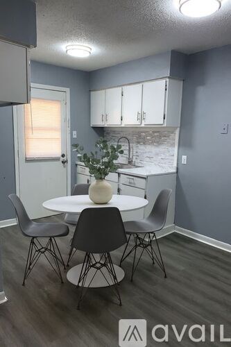 A dining room with a white table and chairs.