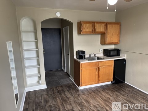 A kitchen area with a sink, microwave, and cabinets.