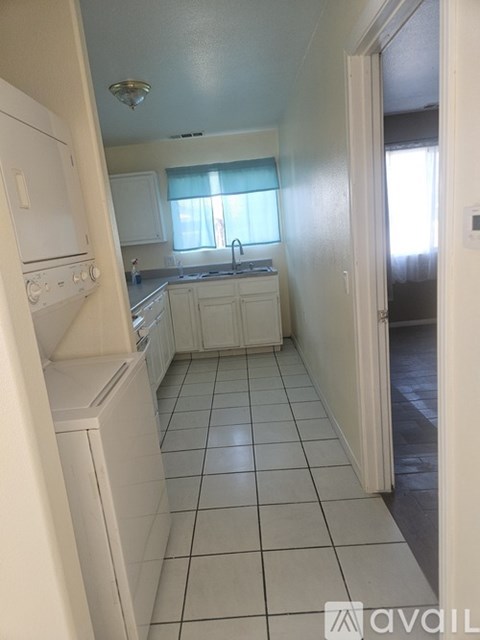 A kitchen with white appliances and white cabinets.