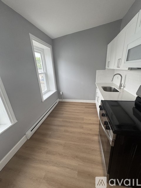 A kitchen with a black countertop and white cabinets.