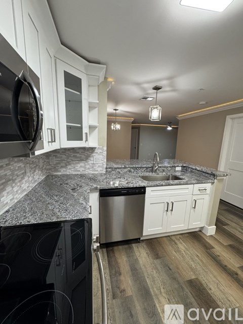 A kitchen with a granite countertop and stainless steel appliances.