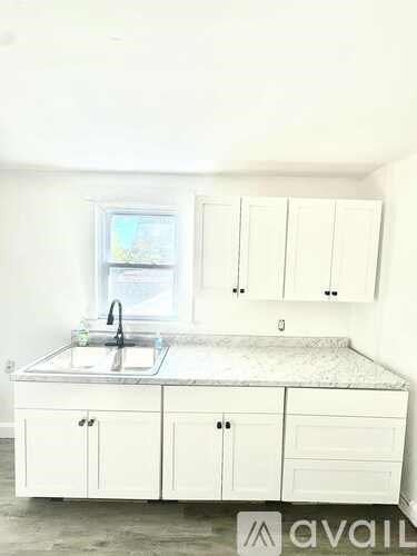 A kitchen with a granite countertop and white cabinets.