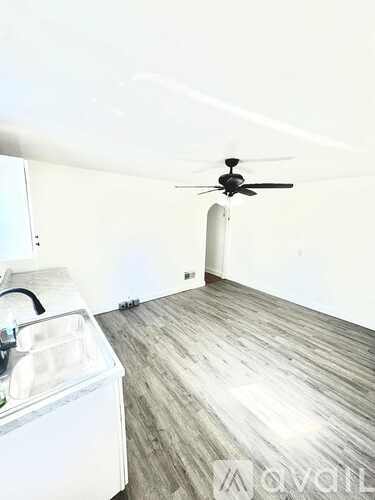 A room with a ceiling fan and a washing machine.