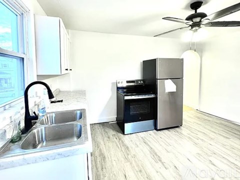 A room with a ceiling fan and a washing machine.