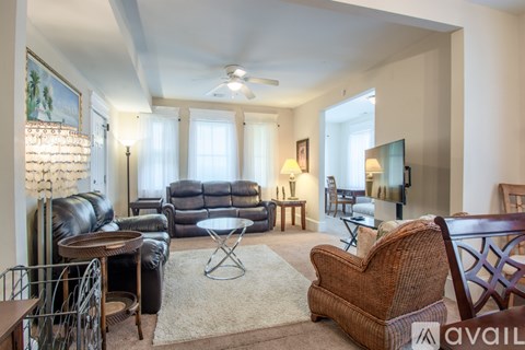A living room with a brown wicker chair in the foreground.