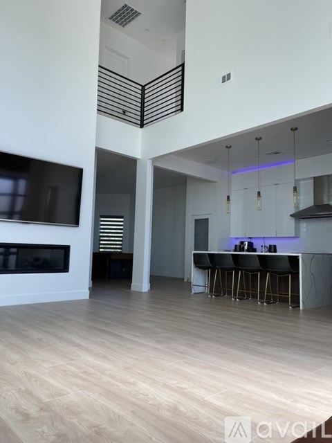 A modern kitchen with a bar area and a television mounted on the wall.