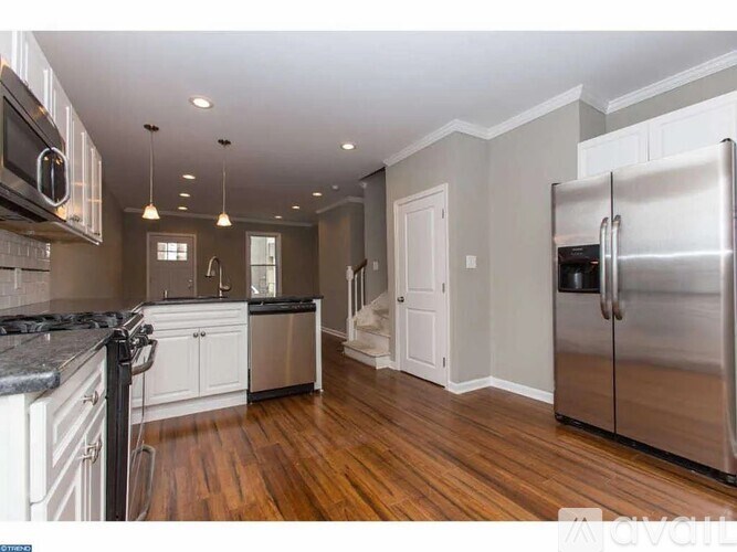 A kitchen with a refrigerator on the right side.
