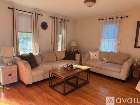 A living room with a large sectional sofa, a coffee table, and a side table with a lamp.