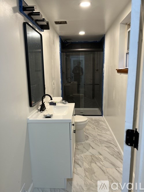 A bathroom with a white sink and a mirror above it.