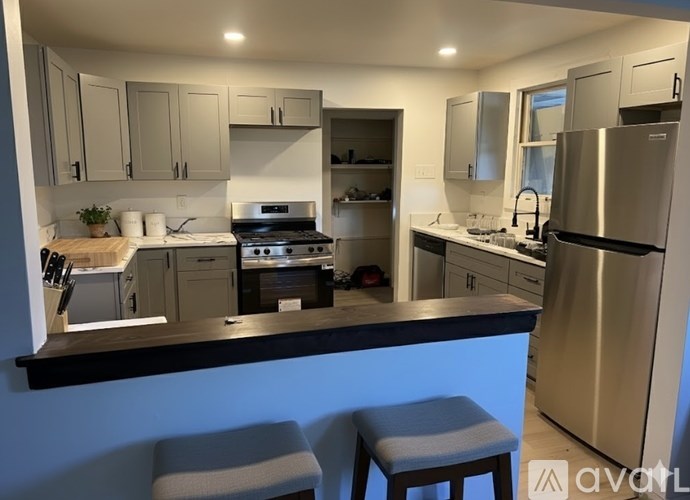 A kitchen with a stove top oven and a refrigerator.