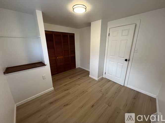 A room with wooden flooring and a white door.