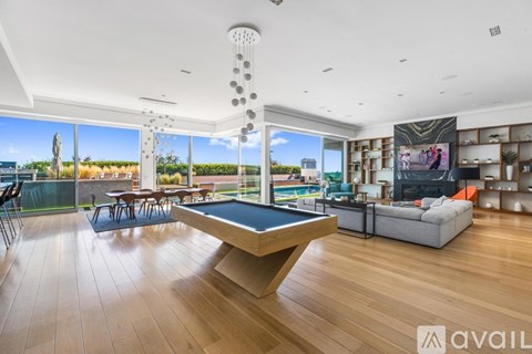 A modern living room with a pool table and a view of the outdoors.