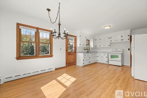 A kitchen with wooden floors and white walls.
