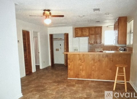 A kitchen with a wooden counter and a ceiling fan.