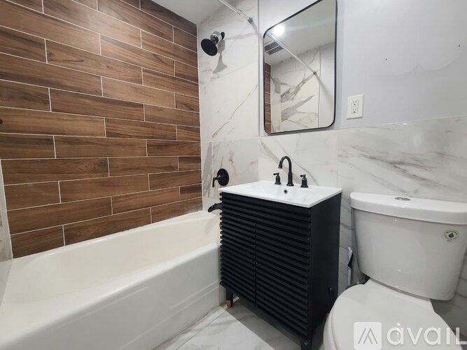 A bathroom with a marble wall and a white tub.