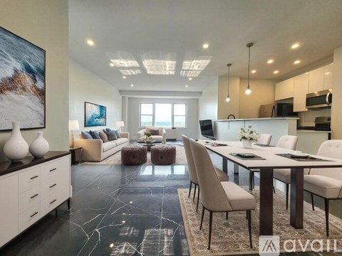 A modern kitchen and living room with a large painting on the wall.