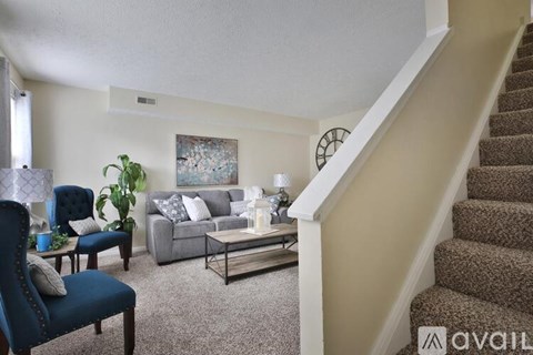 A living room with a blue chair and a grey couch.