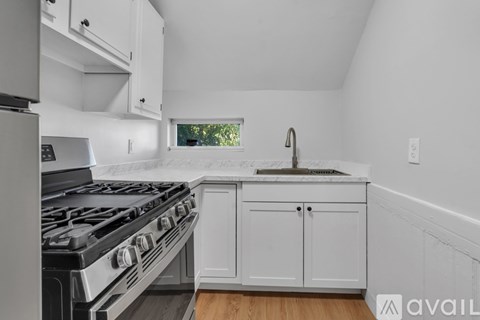 A kitchen with a black stove top oven and white cabinets.