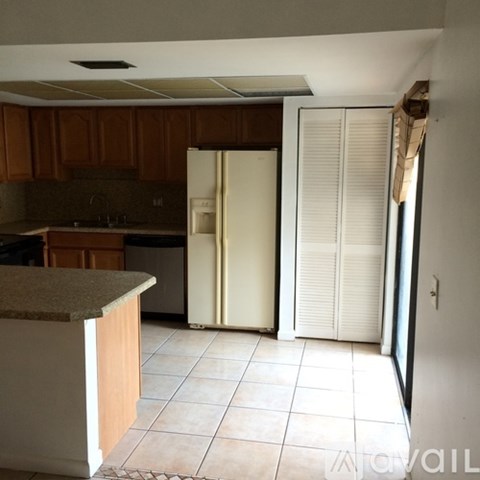 A kitchen with a refrigerator and a counter.